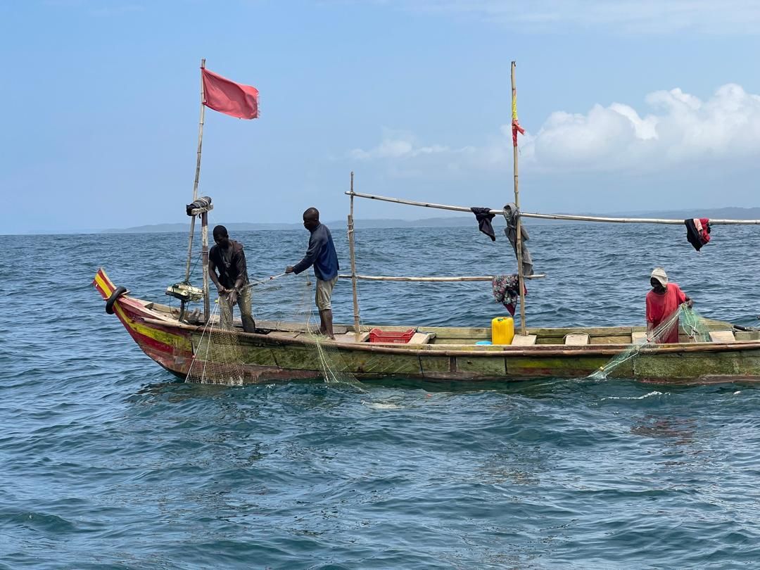 Fishermen pulling in nets from a canoe off the Dixcove coast