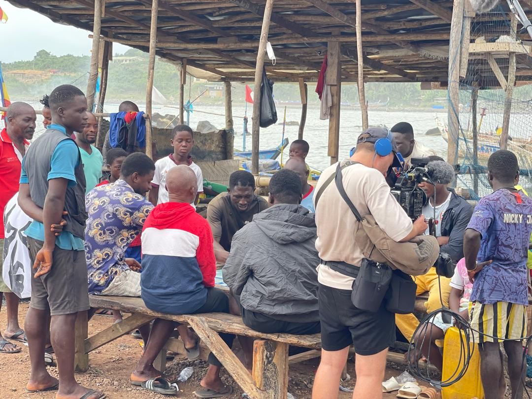 Crew filming a community gathering at the fishing harbour in Dixcove