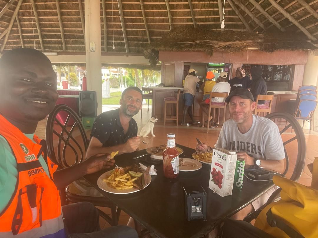 Crew and security escort sharing a lunch break during the Dixcove shoot