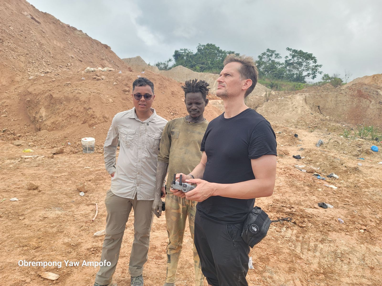 Crew and a local miner preparing for a drone flight over a mining area