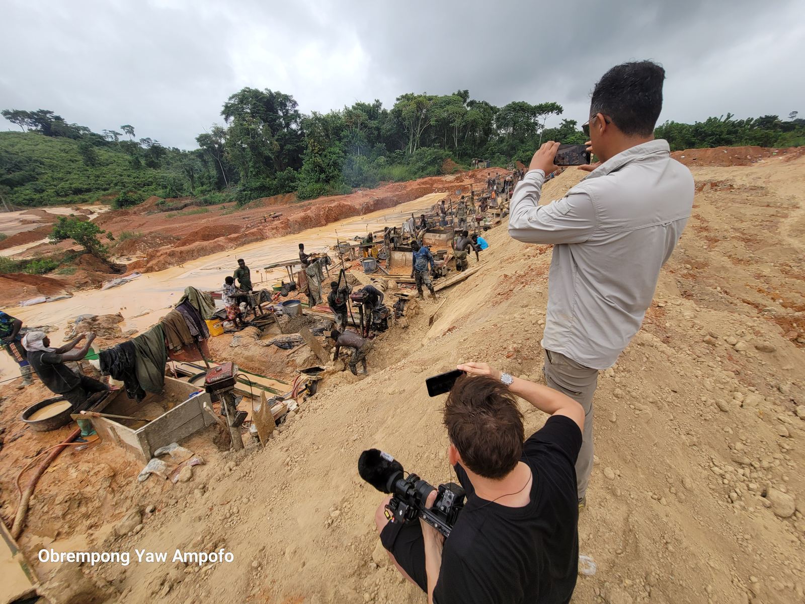Crew overlooking a long stretch of small-scale mining operations from a ridge